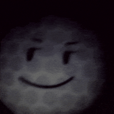a golf ball with a smiley face on it in the dark
