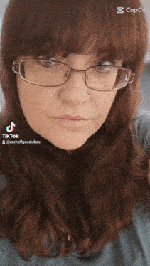 a woman wearing glasses and a blue shirt has a tiktok account named rachelgoodvibes