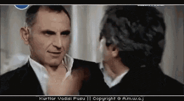two men are standing next to each other and the words kurtlar vadisi pusu are on the bottom of the screen