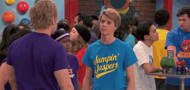 a man wearing a jumpin ' jaspers shirt stands in a crowd