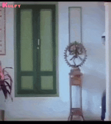 a room with a green door and a statue on a stand