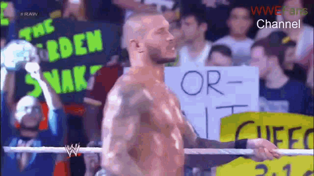 a man in a wrestling ring holds a sign that says " or "