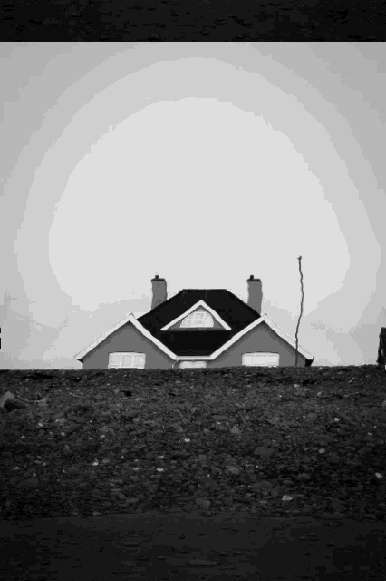 a black and white photo of a house with a triangle roof