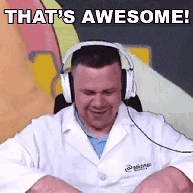 a man wearing headphones and a lab coat is smiling and saying `` that 's awesome '' .