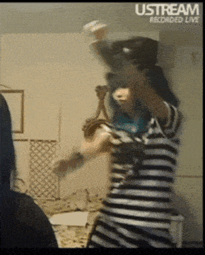 a woman with blue hair is dancing in front of a sign that says ustream