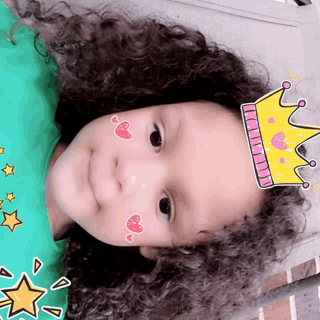 a little girl with a crown on her head and hearts on her face