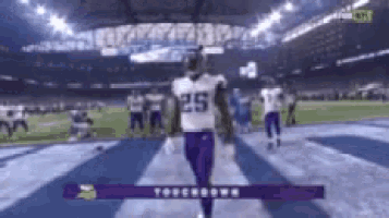 a football player with the number 25 on his jersey is walking on the field