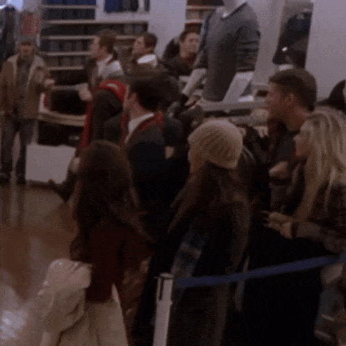 a group of people are standing in a line in front of a mannequin
