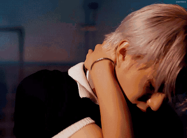 a man with a bracelet on his wrist is laying down with his head on someone 's lap