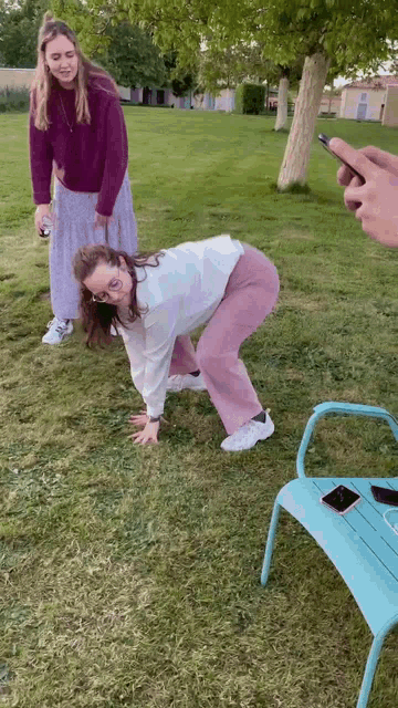 a person taking a picture of a woman on the ground
