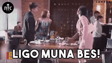 a group of people standing around a table with the words " ligo muna bes " written on the bottom