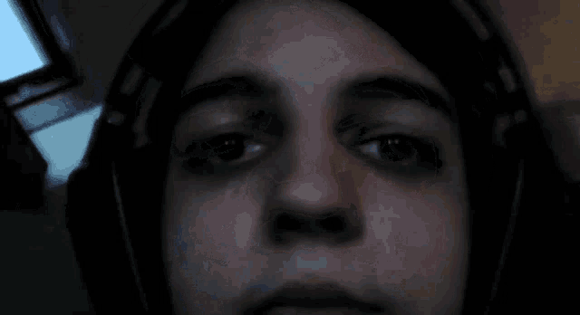 a close up of a person wearing headphones and looking at the camera