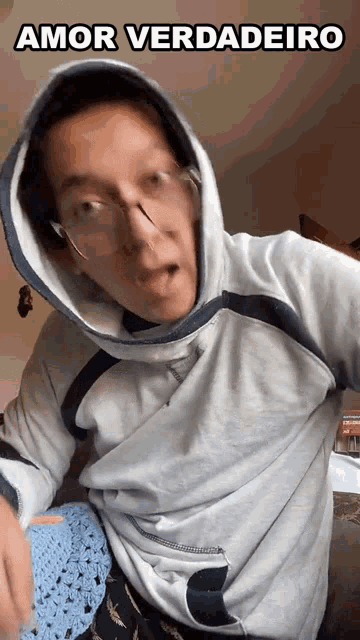 a man wearing glasses and a hooded sweatshirt with the words amor verdadeiro above him