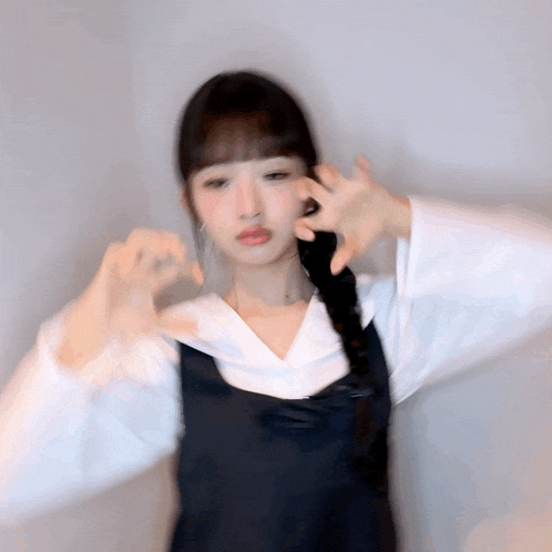 a blurry photo of a woman making a heart shape with her hands