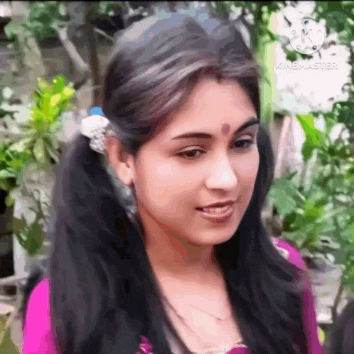 a close up of a woman 's face with pigtails and a bindi on her forehead .