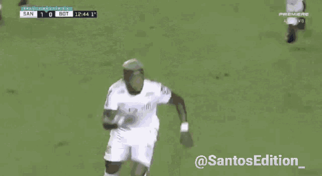 a soccer player is running on the field during a game sponsored by @santosedition