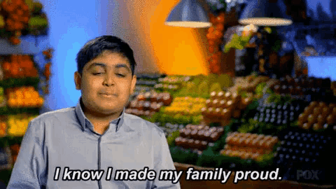 a boy says " i know i made my family proud " in front of a fruit stand
