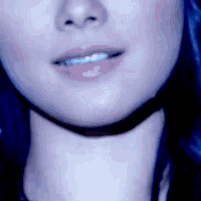 a close up of a woman 's face with blue hair and pink lips