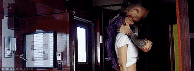 a man and woman are kissing in a room with directors-eyes written on the bottom right