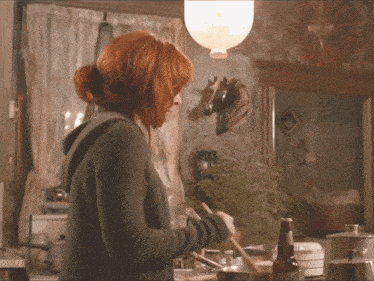 a woman stirs a pot with a wooden spoon