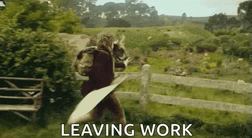 a man is walking through a field carrying a piece of paper and a sign that says `` leaving work '' .