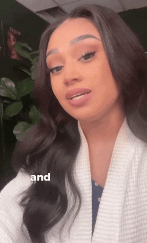 a woman is wearing a white robe and the word and is on the bottom