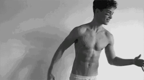 a black and white photo of a shirtless young man in underwear .