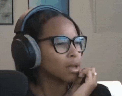 a woman wearing glasses and headphones is making a funny face .