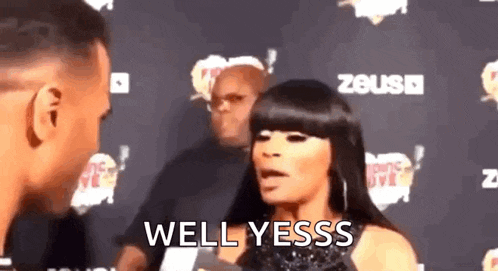 a woman is talking to a man on a red carpet and saying `` well yessss '' .