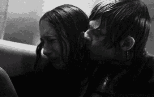 a black and white photo of a man kissing a woman on the cheek in a bathtub .