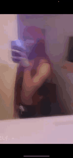 a woman with red hair is taking a selfie in the mirror .