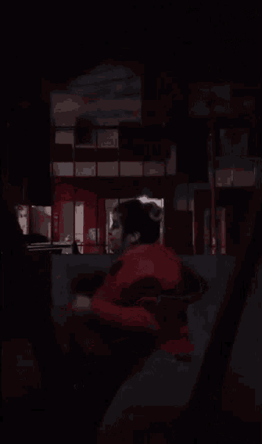 a woman with a very large breast is dancing in the dark