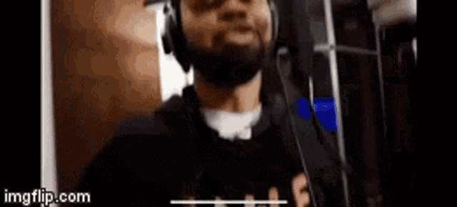 a man with a beard wearing headphones and a microphone .