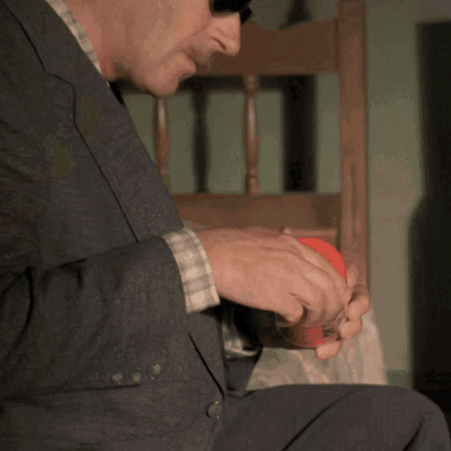 a man wearing sunglasses sits in a chair