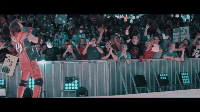 a crowd watching a wrestling match with a sign that says ' i love ny '
