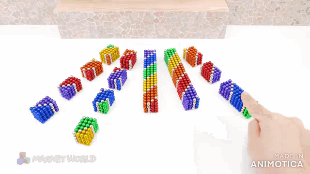 a rainbow colored house made out of magnets and a square made out of magnets