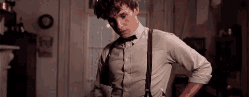 a man in a bow tie and suspenders is standing in a living room .