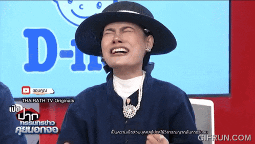 a woman wearing a hat is laughing in front of a screen that says d-ii