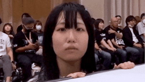 a group of people are sitting in a room with a woman sitting in front of them .