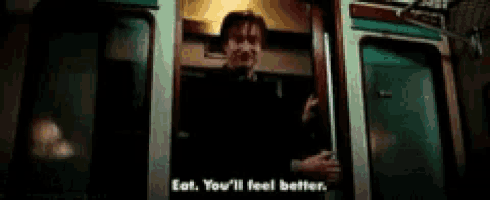 a man in a suit and tie is standing in a doorway and talking to someone .