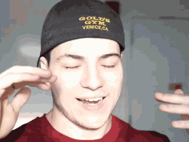 a man wearing a black hat that says gold 's gym on it