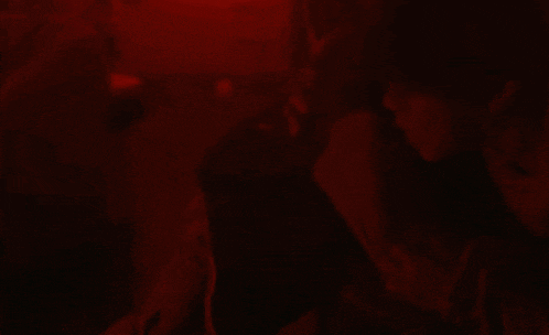 a blurry picture of two people hugging in a dark room