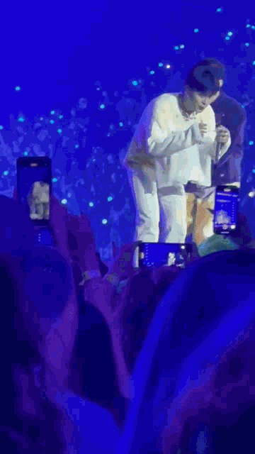 a person taking a picture of a person on stage with a cell phone