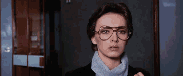 a woman wearing glasses and a turtleneck sweater