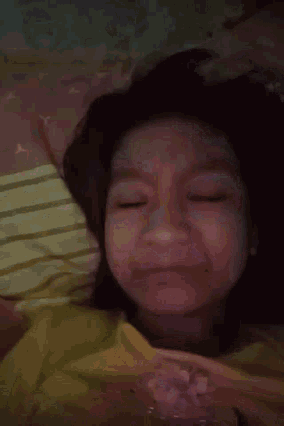 a close up of a woman laying on a bed with her eyes closed