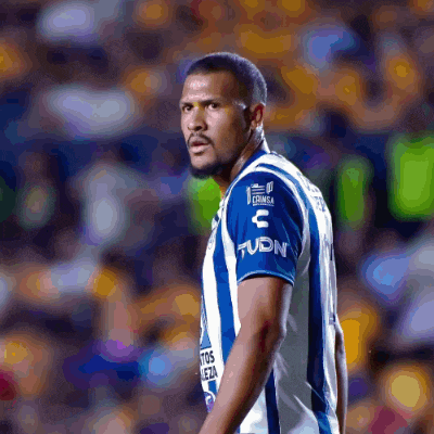 a man wearing a blue and white striped shirt that says tudn on it