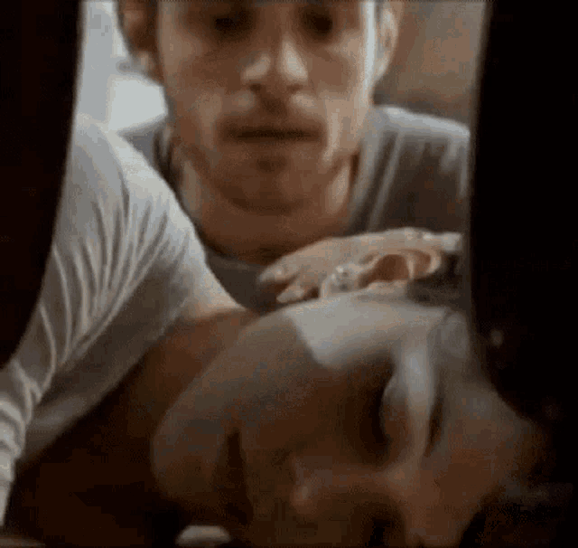 a close up of a man holding a woman 's face in his arms .