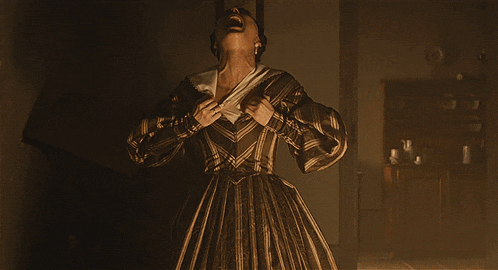 a woman in a brown dress is screaming and taking off her top