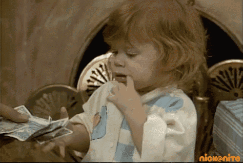 a little girl is holding a bunch of money in front of a nick nitro logo