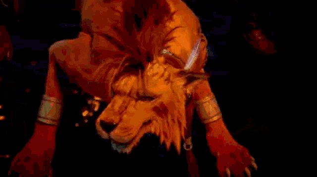 a lion with blood on its face is laying on a bed .